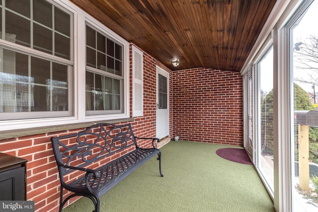 sunroom / solarium featuring wooden ceiling and vaulted ceiling