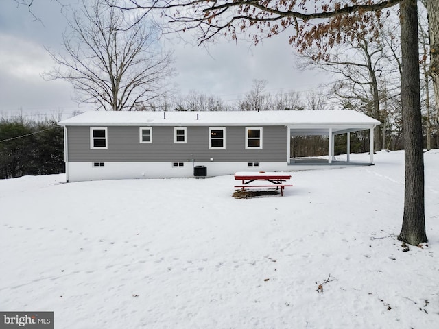 snow covered house with central air condition unit