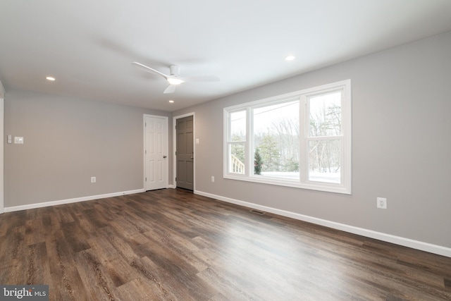 empty room with dark hardwood / wood-style floors and ceiling fan