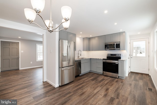 kitchen with stainless steel appliances, hanging light fixtures, gray cabinets, and sink