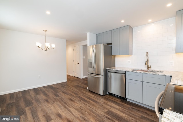 kitchen with gray cabinets, pendant lighting, sink, stainless steel appliances, and dark wood-type flooring