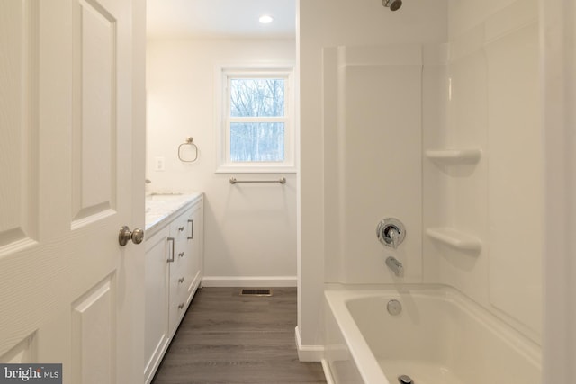 bathroom featuring hardwood / wood-style flooring, vanity, and bathtub / shower combination