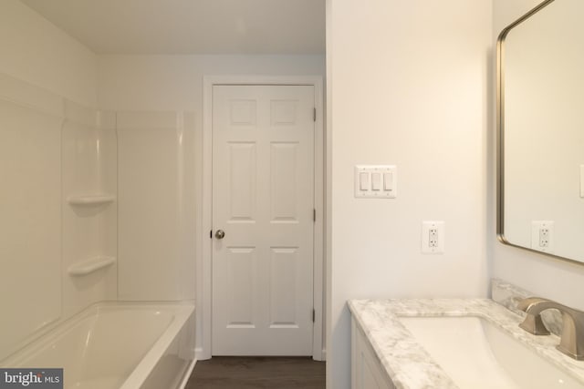 bathroom featuring vanity, hardwood / wood-style flooring, and shower / washtub combination