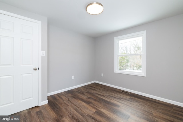 empty room with dark wood-type flooring