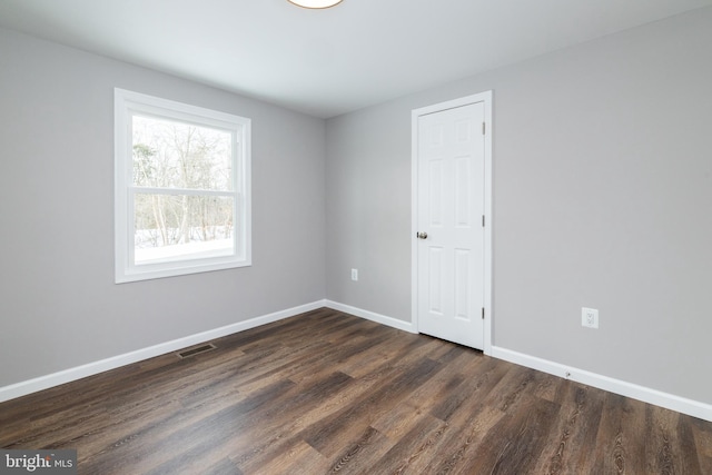 spare room featuring dark wood-type flooring