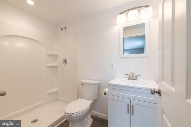 bathroom with vanity, a shower, and toilet