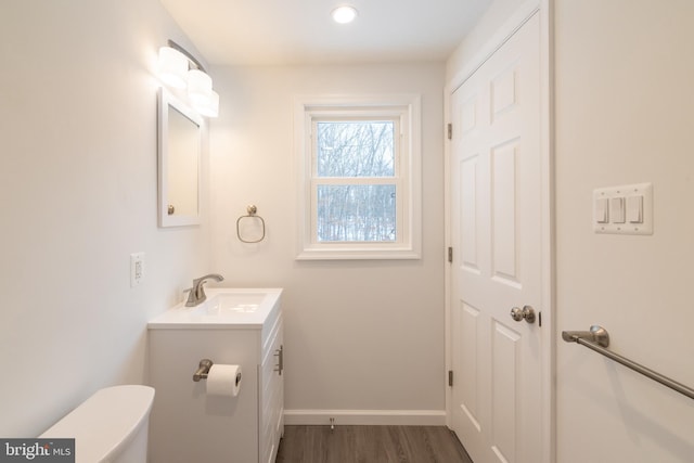 bathroom with vanity, toilet, and hardwood / wood-style floors