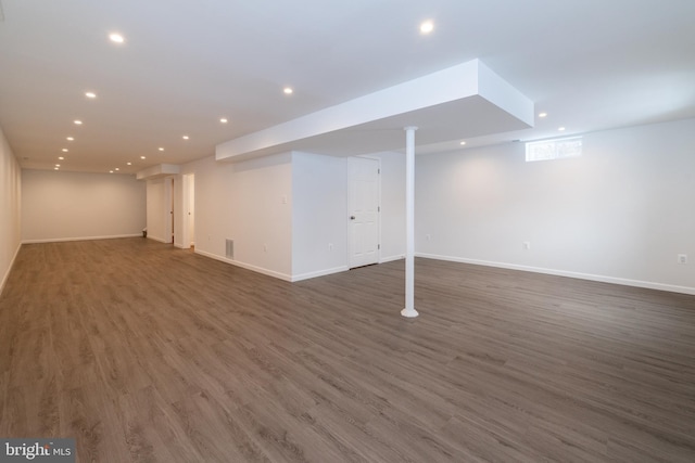 basement with dark hardwood / wood-style floors