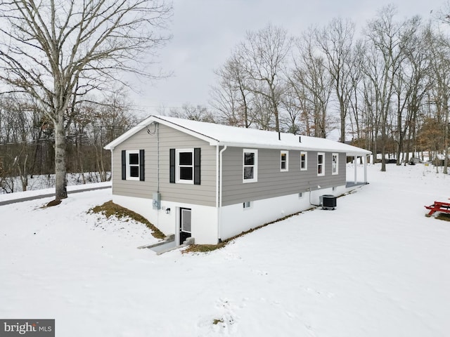 snow covered rear of property with cooling unit