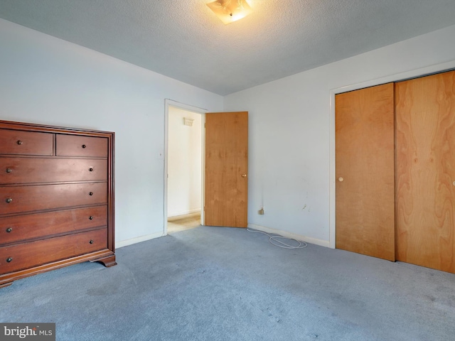 unfurnished bedroom with light colored carpet, a textured ceiling, and a closet