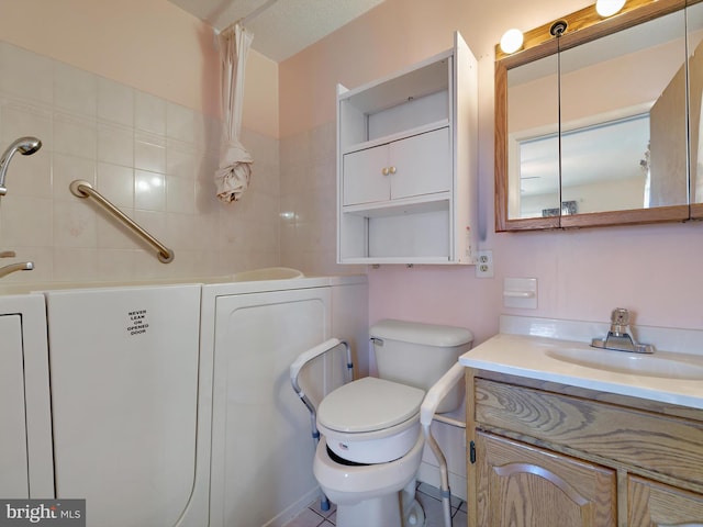 bathroom with a washtub, toilet, and vanity