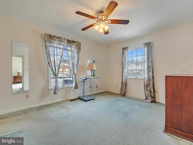 interior space with ceiling fan and light carpet