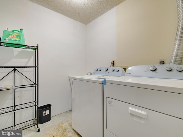 clothes washing area with a textured ceiling and separate washer and dryer