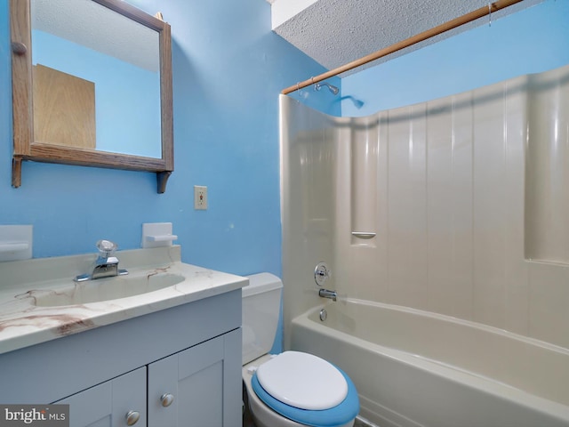 full bathroom featuring a textured ceiling, toilet,  shower combination, and vanity