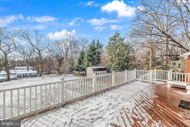 snow covered deck with a shed