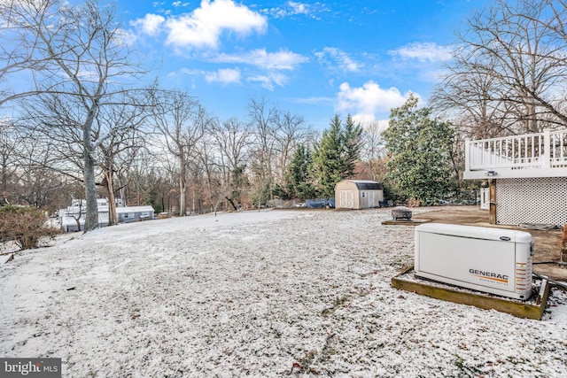 yard layered in snow with a wooden deck and a storage unit