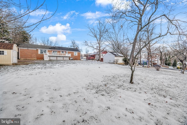 snowy yard with a storage shed