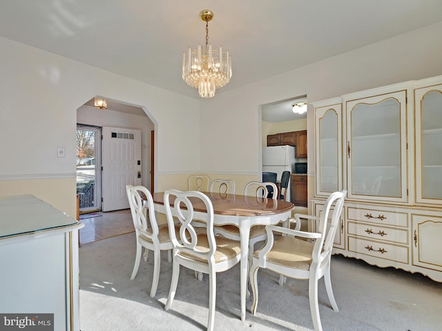 carpeted dining space featuring a chandelier