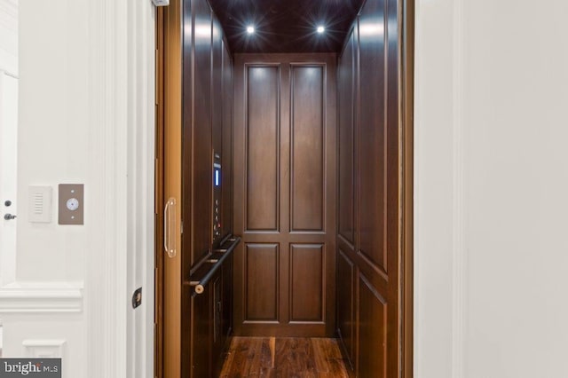 details with hardwood / wood-style flooring and elevator