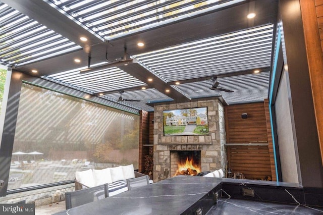 view of patio / terrace featuring ceiling fan and an outdoor stone fireplace