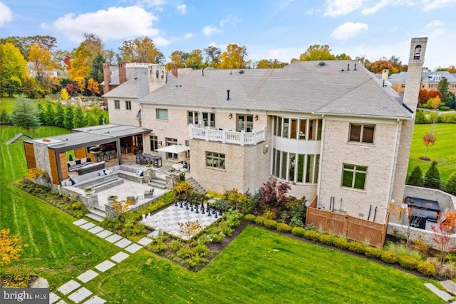 back of house with an outdoor living space, a balcony, a yard, and a patio