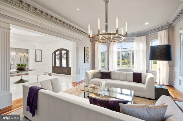 living room featuring ornamental molding, a chandelier, and light wood-type flooring