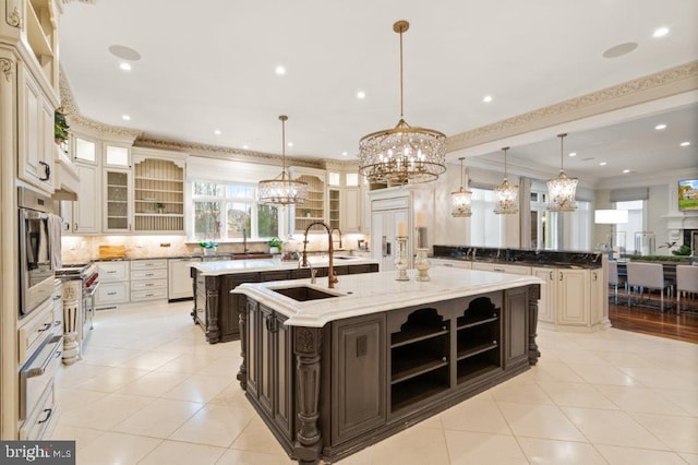 kitchen featuring light stone countertops, light tile patterned floors, a large island with sink, and pendant lighting