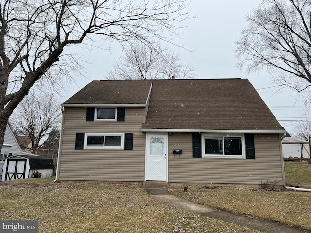 view of front facade with a front lawn and a storage shed