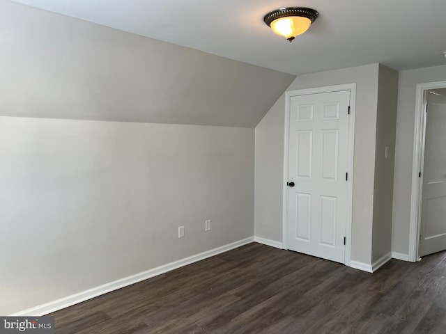 bonus room with vaulted ceiling and dark hardwood / wood-style floors