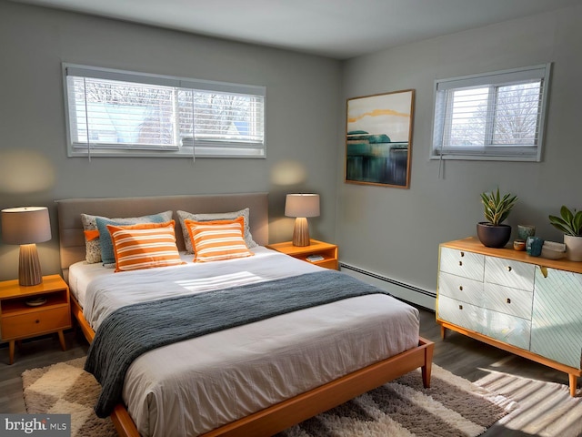 bedroom with dark wood-type flooring, a baseboard radiator, and multiple windows