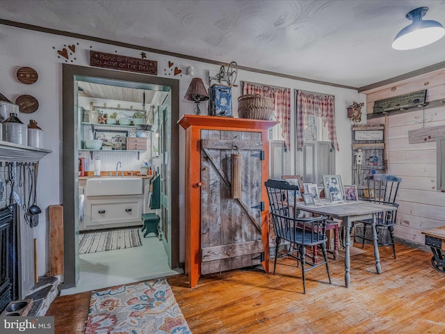 dining room featuring wood walls, sink, and light wood-type flooring