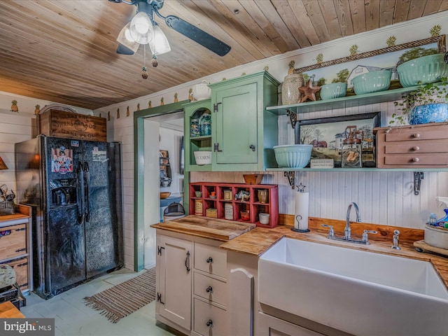 kitchen featuring black fridge with ice dispenser, sink, butcher block countertops, wooden ceiling, and green cabinets