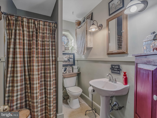 bathroom featuring curtained shower and toilet