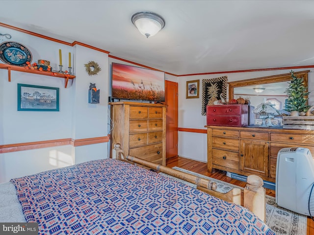 bedroom featuring crown molding and light hardwood / wood-style flooring