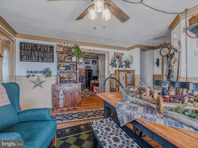 living room with crown molding, ceiling fan, and hardwood / wood-style flooring