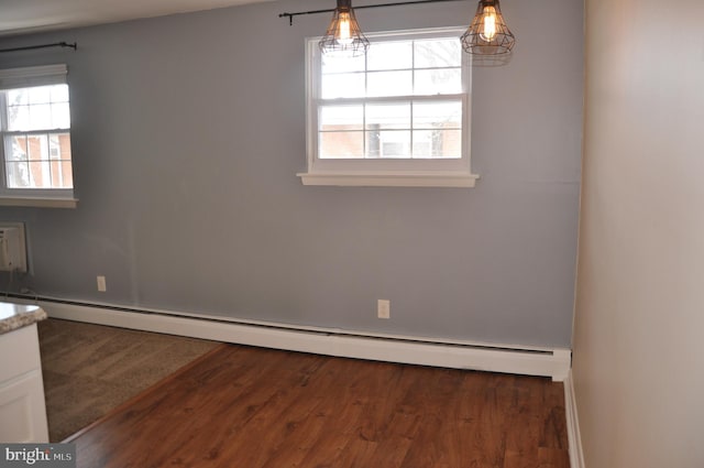 unfurnished dining area with dark hardwood / wood-style floors and a baseboard radiator