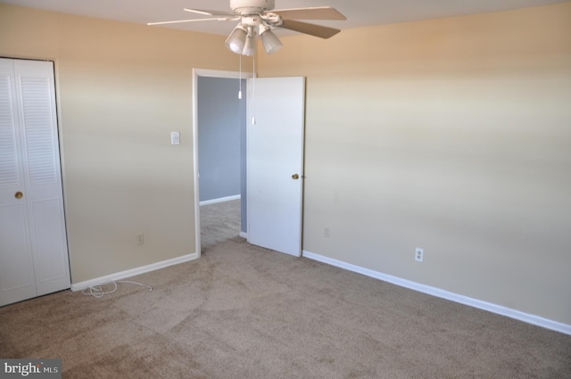 unfurnished bedroom featuring ceiling fan, light colored carpet, and a closet