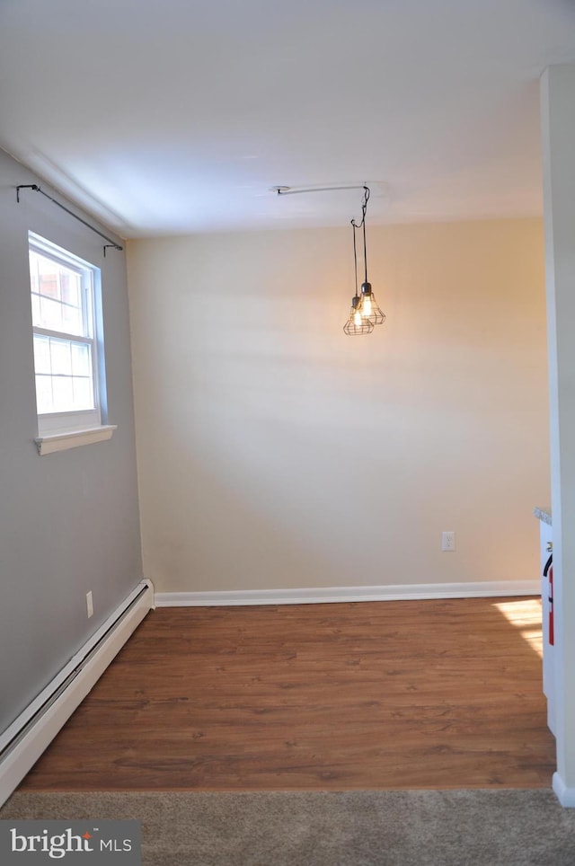 empty room with baseboard heating and dark hardwood / wood-style floors