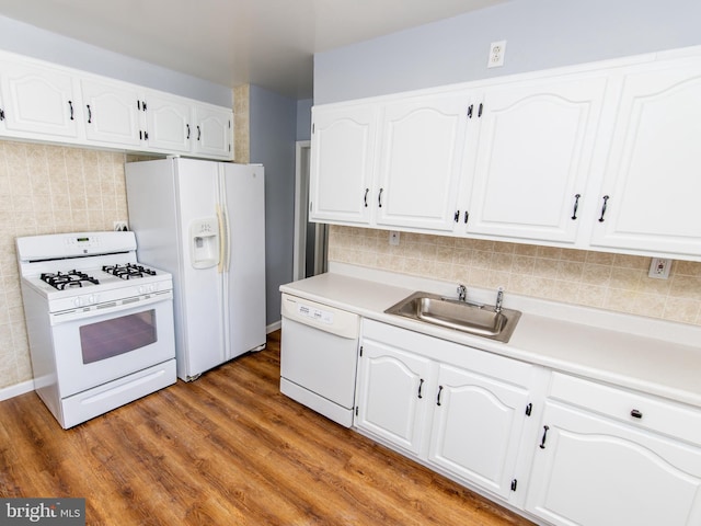 kitchen featuring sink, white appliances, white cabinets, and hardwood / wood-style flooring