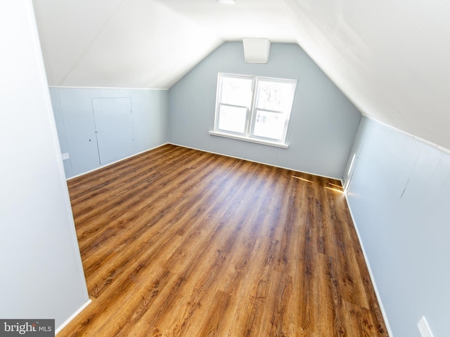 bonus room with vaulted ceiling and dark wood-type flooring