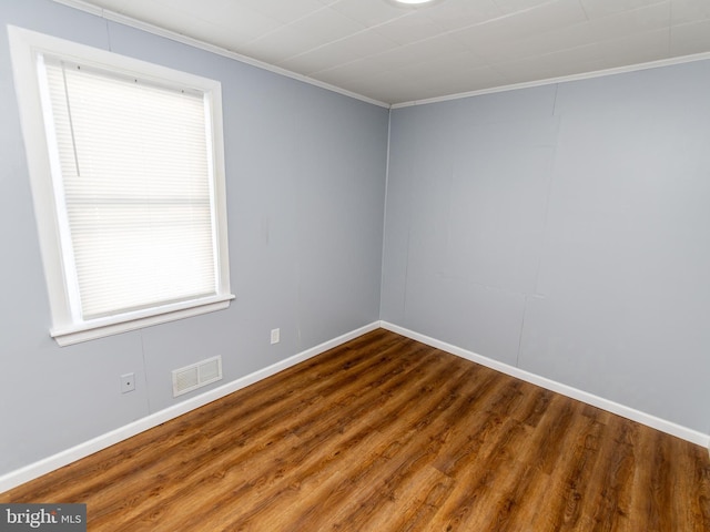 empty room with hardwood / wood-style flooring and ornamental molding