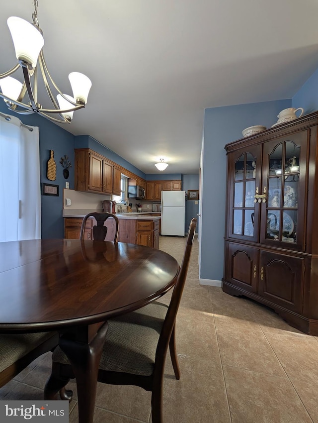 tiled dining room featuring an inviting chandelier