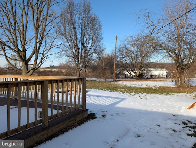 yard covered in snow featuring a wooden deck