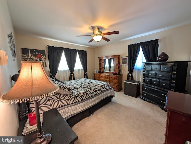 bedroom with ceiling fan and light carpet