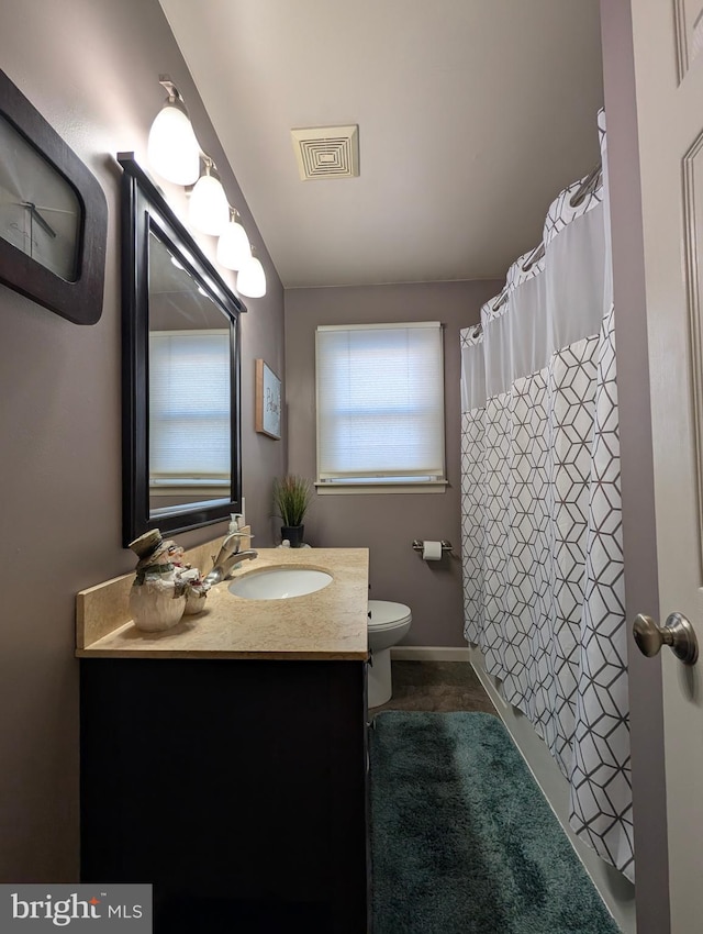 bathroom with vanity, toilet, and walk in shower