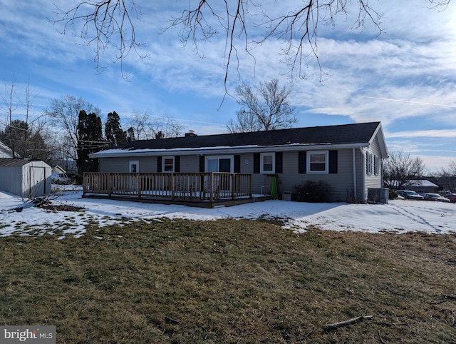 view of front of home featuring central AC unit, a storage unit, a yard, and a deck