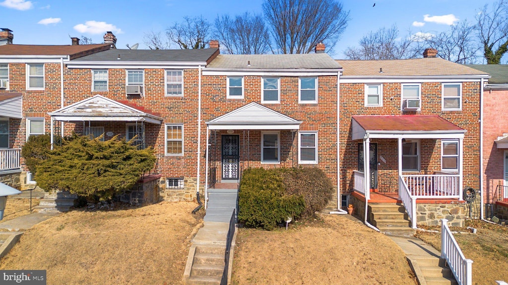 view of property with cooling unit, a front yard, and covered porch