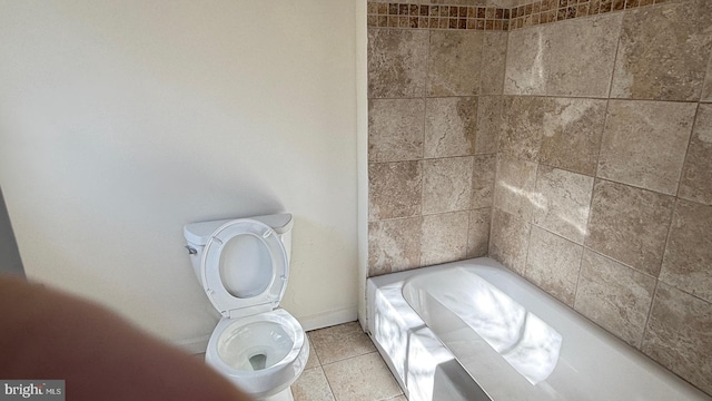 bathroom with toilet, tile patterned flooring, and a washtub