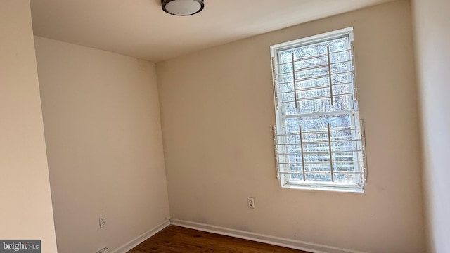 spare room featuring dark wood-type flooring and a wealth of natural light