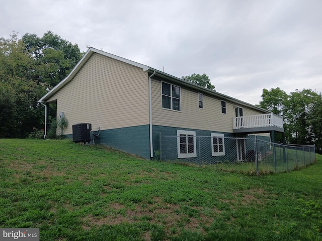 view of side of home with central air condition unit and a yard